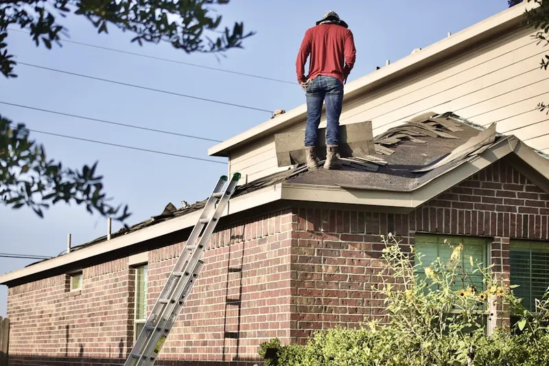 Professional roofer working on a residential roof in International District